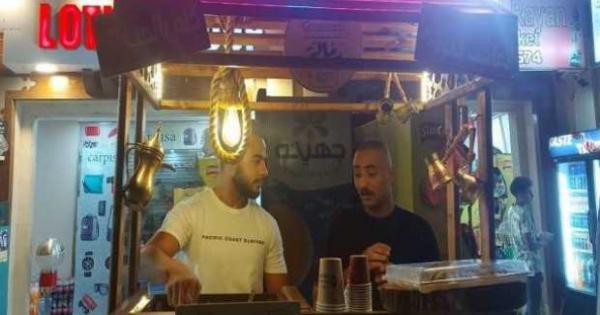 صور- فناجين بسكويت بطعم الشيكولاته.. شابان يصنعان قهوة على الرمل بالأقصر