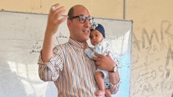 عميد تجارة كفر الشيخ يحمل طفلة رضيعة ابنة طالبة بالدراسات العليا أثناء شرحه