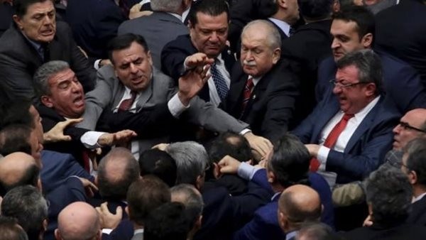 لكمات بالأيدي وتقطيع ملابس، سر ضرب وزير العدل في اشتباكات عنيفة بالبرلمان التركي (فيديو)